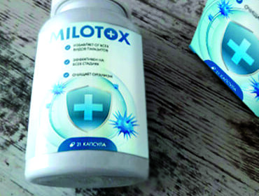 Упаковка и баночка препарата Milotox лежат на столе.